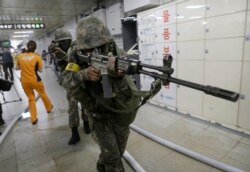 FILE - South Korean army soldiers aim their weapons during an anti-terror drill as part of Ulchi Freedom Guardian exercise, at Sadang Subway Station in Seoul, South Korea, Aug. 19, 2015.