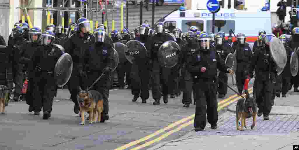 British police officers charge rioters, during riots in Hackney, east London, Monday Aug. 8, 2011. Youths set fire to shops and vehicles in a host of areas of London _ which will host next summer's Olympic Games _ and clashed with police in the nation's 