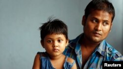 Abdul Rahim, seorang pengungsi Rohingya dari Myanmar, beserta putrinya Morja, dalam wawancara di rumah susun mereka di Kuala Lumpur , Mei 2013. (Reuters/Bazuki Muhammad)