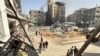 Palestinians walk past damaged and destroyed buildings in Beit Lahia the northern Gaza Strip, Oct. 26, 2024. 