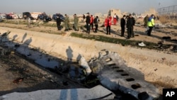 Debris is seen from an Ukrainian plane which crashed as authorities work at the scene in Shahedshahr, southwest of the capital Tehran, Iran, Wednesday, Jan. 8, 2020. A Ukrainian airplane carrying 176 people crashed on Wednesday shortly after takeoff…