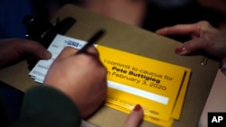 A person signs up to caucus for Democratic presidential candidate former South Bend, Ind., Mayor Pete Buttigieg, following a town hall meeting in Fort Dodge, Iowa, Jan. 25, 2020. 