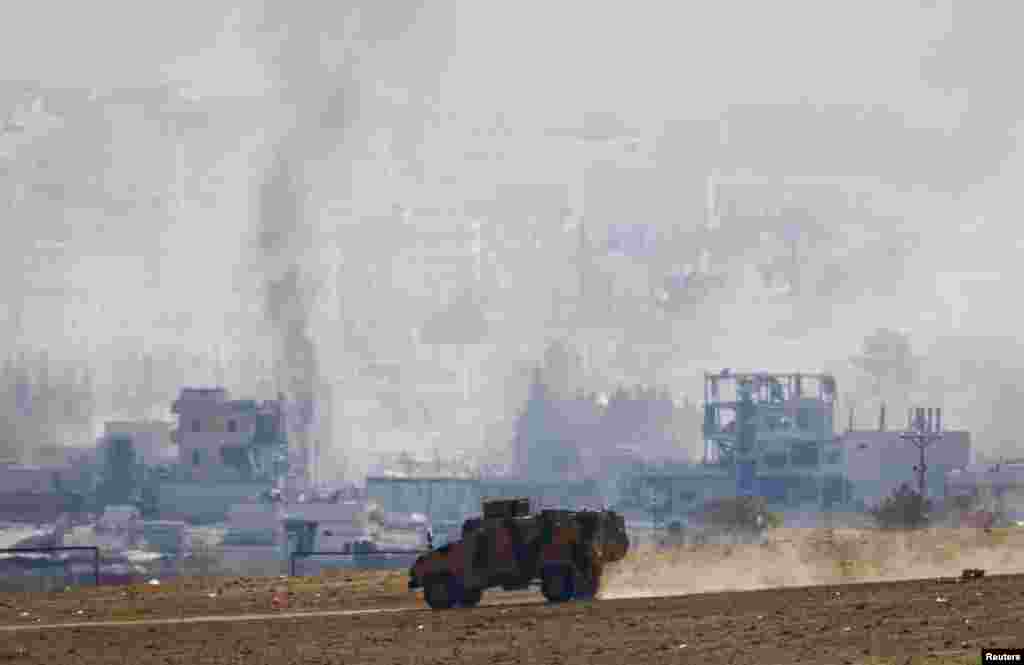 Smoke rises from the Syrian town of Kobani as a Turkish army vehicle takes position near the Mursitpinar border crossing in town of Suruc, Oct. 29, 2014.