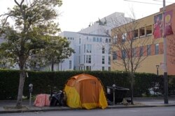 A tent is seen on a sidewalk just around the corner from the Opera House with a residential building in the background in San Francisco, Dec. 2, 2021.