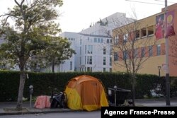 A tent is seen on a sidewalk just around the corner from the Opera House with a residential building in the background in San Francisco, Dec. 2, 2021.