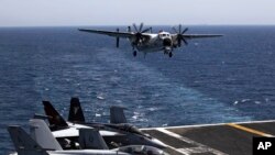 FILE - A plane lands on the U.S. Navy aircraft carrier USS George H.W. Bush, in the Persian Gulf. 