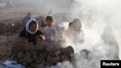 Displaced people from the minority Yazidi sect, who fled violence in the Iraqi town of Sinjar, are seen as they prepare tea for breakfast at Bajed Kadal refugee camp, southwest of Dohuk province, August 23, 2014. REUTERS/Youssef Boudlal (IRAQ - Tags: POLI