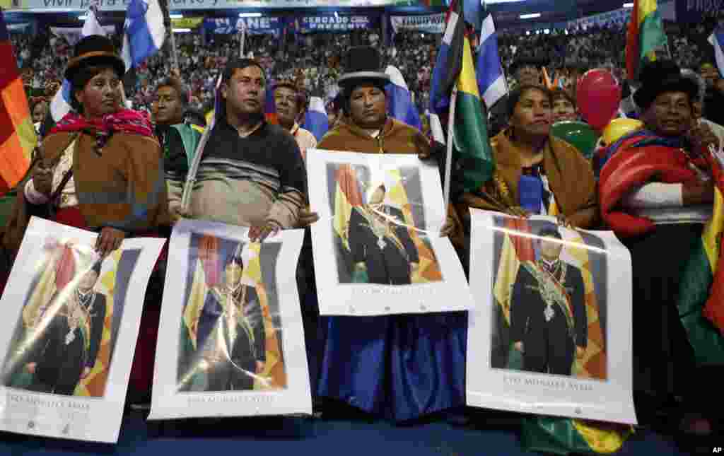 Aymara women hold a posters of Bolivia's President Evo Morales during a welcome ceremony for presidents attending a meeting in Cochabamba, Bolivia, July 4, 2013. 