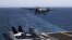 FILE - A plane lands on the U.S. Navy aircraft carrier USS George H.W. Bush, in the Persian Gulf. 
