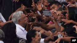 Presiden Meksiko Andrés Manuel López Obrador menyapa para pendukungnya saat tiba di alun-alun utama Ibu Kota, Zócalo, di Mexico City, Minggu, 27 November 2022. (Foto: AP/Marco Ugarte)