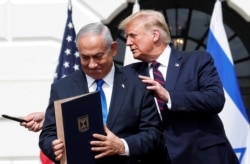 FILE - Israel's Prime Minister Benjamin Netanyahu stands with U.S. President Donald Trump after signing the Abraham Accords, on the South Lawn of the White House in Washington, Sept. 15, 2020.