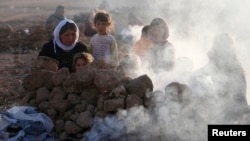 Displaced people from the minority Yazidi sect, who fled violence in the Iraqi town of Sinjar, are seen as they prepare tea for breakfast at Bajed Kadal refugee camp, southwest of Dohuk province, Aug. 23, 2014. 