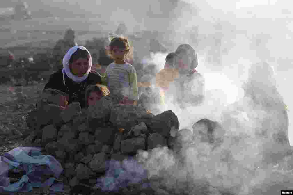 Displaced people from the minority Yazidi sect, who fled violence in the Iraqi town of Sinjar, are seen as they prepare tea for breakfast at Bajed Kadal refugee camp, southwest of Dohuk province, August 23, 2014. REUTERS/Youssef Boudlal (IRAQ - Tags: POLI