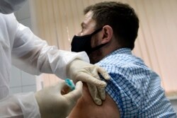 RUSSIA -- A nurse inoculates volunteer Ilya Dubrovin, 36, with Russia's new coronavirus vaccine in a post-registration trials at a clinic in Moscow, Sept. 10, 2020.