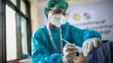 ရန်ကုန်မြို့ ဧရာဝတီကိုဗစ်စင်တာမှာ ကျန်းမာရေးဝန်ထမ်းတဦးကို ကိုဗစ်-၁၉  ကာကွယ်ဆေးထိုးပေးနေစဉ်။ (ဇန်နဝါရီ ၂၇၊ ၂၀၂၃)  