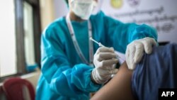 ရန်ကုန်မြို့ ဧရာဝတီကိုဗစ်စင်တာတခုမှာ ကိုဗစ်ကာကွယ်ဆေးထိုးနှံနေတဲ့ ကျန်းမာရေးဝန်ထမ်းတဦး။ (ဇန်နဝါရီ ၂၇၊ ၂၀၂၁)