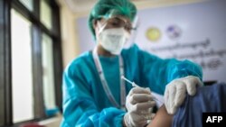 A health worker receives a vaccine for the Covid-19 coronavirus at the Ayeyarwady Covid Center in Yangon on January 27, 2021. (Photo by Sai Aung Main / AFP)