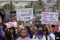 Women hold signs against gender-based violence and in favor of abortion on International Women's Day, in Chihuahua, Mexico on March 8, 2023. (AP Photo/Adriana Esquivel)