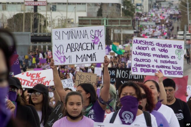 Women hold signs against gender-based violence and in favor of abortion on International Women's Day, in Chihuahua, Mexico on March 8, 2023. (AP Photo/Adriana Esquivel)