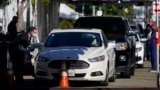 Para nakes menunggu di mobil untuk menjalani vaksinasi COVID-19 di San Diego, California (dok: AP/Gregory Bull)