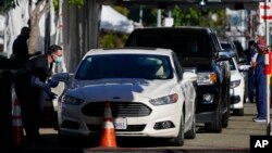 Para nakes menunggu di mobil untuk menjalani vaksinasi COVID-19 di San Diego, California (dok: AP/Gregory Bull)