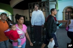 A cardboard life-size cut out of Venezuelan President Nicolas Maduro stands at the entrance of a public park in Caracas, Venezuela, Friday, Jan. 25, 2019. (AP Photo/Rodrigo Abd)