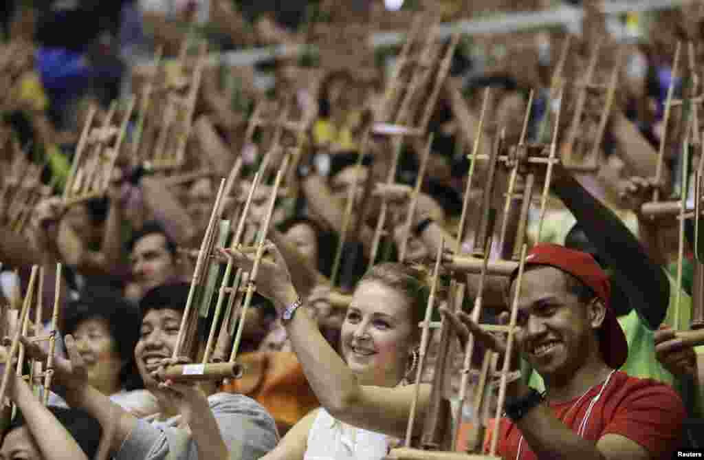 Some 5,390 participants play a song with Anklungs, Indonesian traditional bamboo musical instruments, during a performance in an attempt to break the Guinness World Record for the largest number of people playing Angklung at the Workers Gymnasium in Beiji, China.