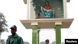 FILE - Members of the police stand guard in front of a replica of Pieta at Holy Rosary Church in Dhaka.