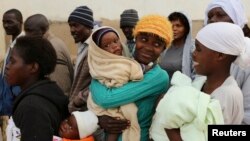 FILE - Zimbabwean women react as they wait to casts their votes at a polling station in Domboshava, about 45 km (28 miles) north of Harare, July 31, 2013.