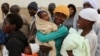 FILE - Zimbabwean women react as they wait to casts their votes at a polling station in Domboshava, about 45 km (28 miles) north of Harare, July 31, 2013.