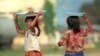 Two young girls carry trays on their heads laden with snacks to sell at a Phnom Penh's railway station. In Cambodia, the total number of rapes reported was up 9 percent from 2009 and up 20 percent from 2008.