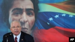 FILE - In this Oct. 10, 2014 file photo, Venezuela's then Foreign Minister Rafael Ramirez gives a press conference backdropped by an image of independence hero Simon Bolivar, in Caracas, Venezuela.