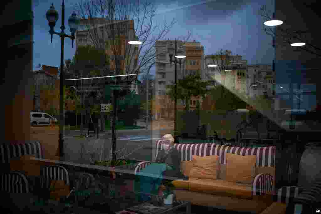 An elderly woman sits in the living room of a nursing home in Barcelona, Spain. Some of Spain's regions are tightening health restrictions for the holidays with new cases already on the rise after remitting in recent weeks. 