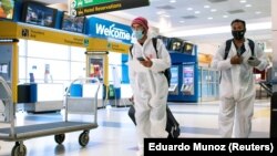 Para penumpang dari London tiba di Bandara Internasional JFK di New York, di tengah pembatasan baru untuk mencegah virus corona (COVID-19), 21 Desember 2020. (Foto: Eduardo Munoz/Reuters)