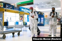 Para penumpang dari London tiba di Bandara Internasional JFK di New York, di tengah pembatasan baru untuk mencegah virus corona (COVID-19), 21 Desember 2020. (Foto: Eduardo Munoz/Reuters)