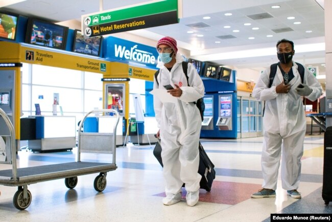 Para penumpang dari London tiba di Bandara Internasional JFK di New York, di tengah pembatasan baru untuk mencegah virus corona (COVID-19), 21 Desember 2020. (Foto: Eduardo Munoz/Reuters)