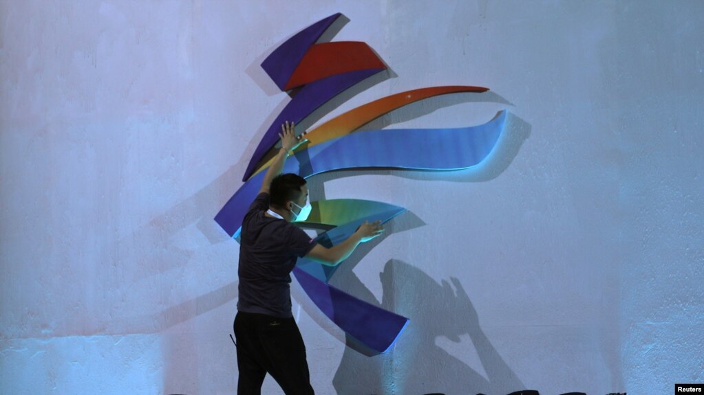 一名男子在调整北京冬奥会的标识。（2021年9月17日）(photo:VOA)