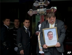 A mourner carries the picture of regional parliament member Vyacheslav Markin, in Odessa, Ukraine, May 5, 2014. Markin, who was known for speaking out against the government in Kyiv.