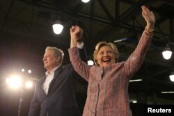 U.S. Democratic presidential nominee Hillary Clinton (R) and former Vice President Al Gore shake hands after talking about climate change at a rally at Miami Dade College in Miami, Florida, U.S. Oct. 11, 2016.