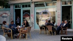 People sit at a cafe at a central square in Nicosia, March 29, 2013.