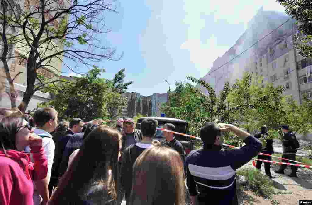 People gather near a multistory apartment that was destroyed by an explosion, in Mykolaiv, southern Ukraine, May 12, 2014.