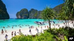 FILE - Tourists enjoy the popular Maya bay on Phi Phi island, Krabi province, March 4, 2017. Authorities ordered the temporary closing of the beach made famous by the Leonardo DiCaprio movie "The Beach" to halt environmental damage caused by too many tourists. 