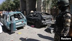 An Afghan security force member keeps watch at the site of a bomb explosion in Herat province, August 15, 2012.