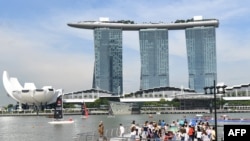 Para turis mengunjungi hotel Marina Bay Sands dari Merlion Park di Singapura, 27 Mei 2018. Kamar-kamar hotel di Singapura sudah dipesan menjelang pertemuan Presiden Donald Trump dan pemimpin Korea Utara, Kim Jong-un, pada 12 Juni.