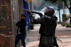 Un policía apunta una escopeta durante una protesta estudiantil en Bogotá, el sábado 23 de noviembre de 2019. Foto AP.