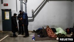 Migrants rest at the transport and logistics centre Bruzgi on the Belarusian-Polish border, in the Grodno region, Belarus, Dec. 21, 2021. 