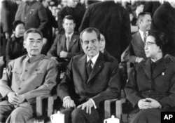 FILE - President Nixon sits between Chinese Premier Chou En-lai and Chiang Ching, wife of Chairman Mao Tse-tung, at a cultural show in the Great Hall of the People, Feb. 22, 1972 in Peking as an interlude in the talks between the two countries leaders.