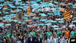 El presidente catalán, Carles Puigdemont, participa de la marcha contra la decisión de la Corte Nacional de encarcelar a los líderes de la sociedad civil, en Barcelona, España, el sábado 21 de octubre de 2017.