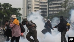 Polisi menembakkan gas air mata ke arah demonstran yang berusaha menerobos barikade (foto, 24/11/2012).