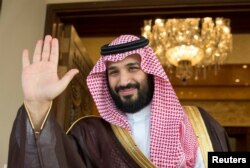 FILE - Saudi Crown Prince Mohammed bin Salman waves as he meets with a visiting official in Riyadh, Saudi Arabia, April 11, 2017.